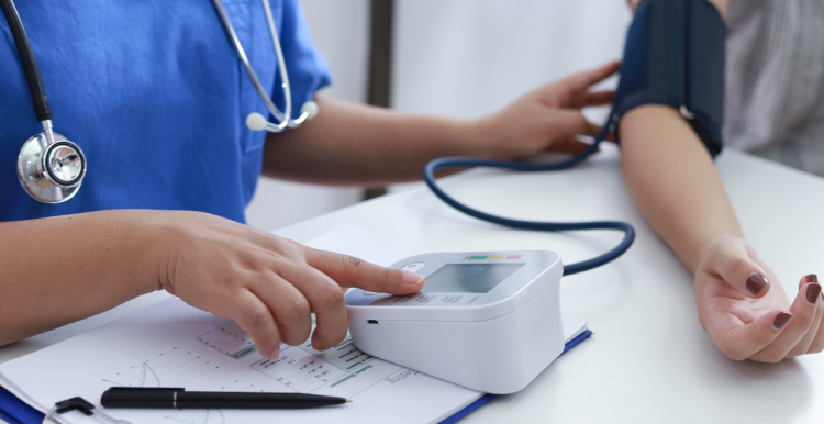 A doctor checking a woman's blood pressure.