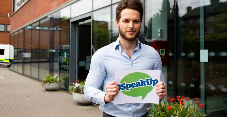 Man holding #Speak Up sign