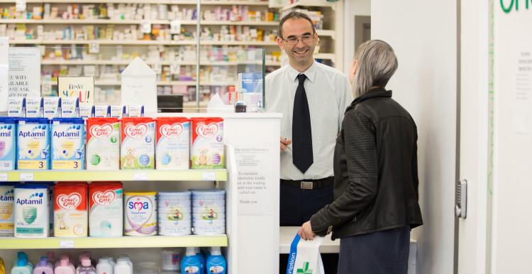 Young woman collecting medication from pharmacist