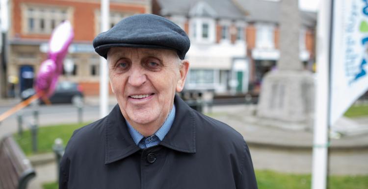 Elderly man standing outside smiling at the camera