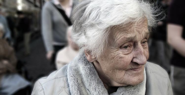 Elderley woman outside in a coat and wheelchair