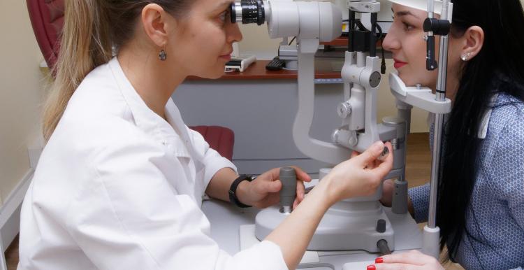 Optometrist checking patient's eye