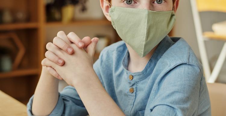 Young boy wearing mask covering lower part of his face