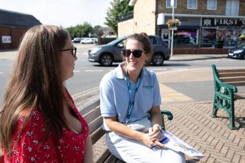 Two women talking on a public bench