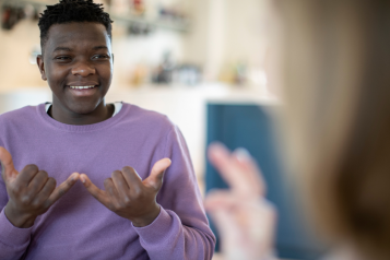 A young person using sign language.