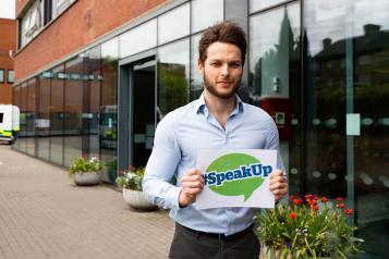 Man holding #Speak Up sign