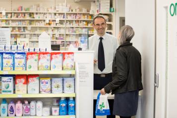 Young woman collecting medication from pharmacist
