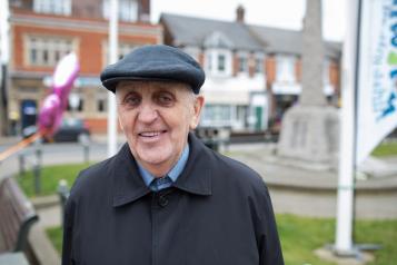 Elderly man standing outside smiling at the camera