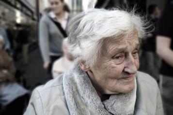 Elderley woman outside in a coat and wheelchair