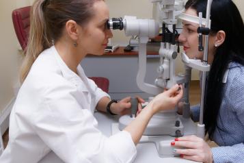 Optometrist checking patient's eye
