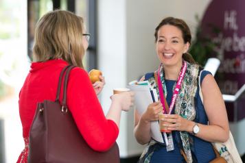 Healthwatch staff members at a conference wearing branded lanyards